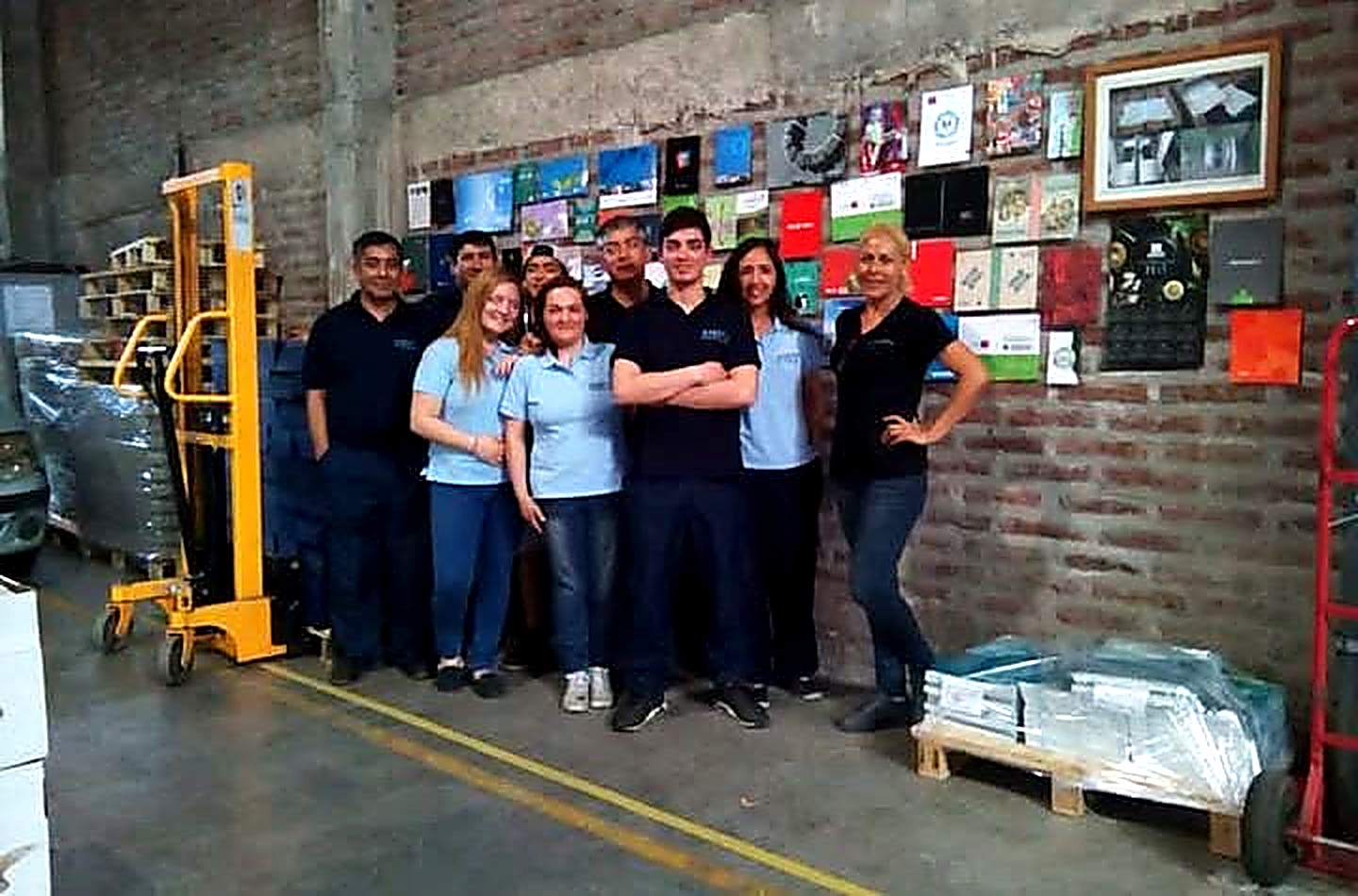 El equipo de Encuadernación e Impresiones Andy reunido en la planta, frente al muro con los trabajos producidos