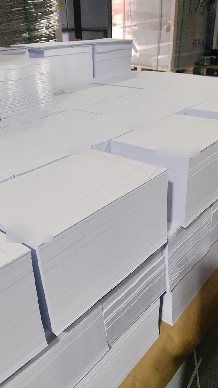 Blocks de papel apilados en la planta, listos para el armado de agendas corporativas